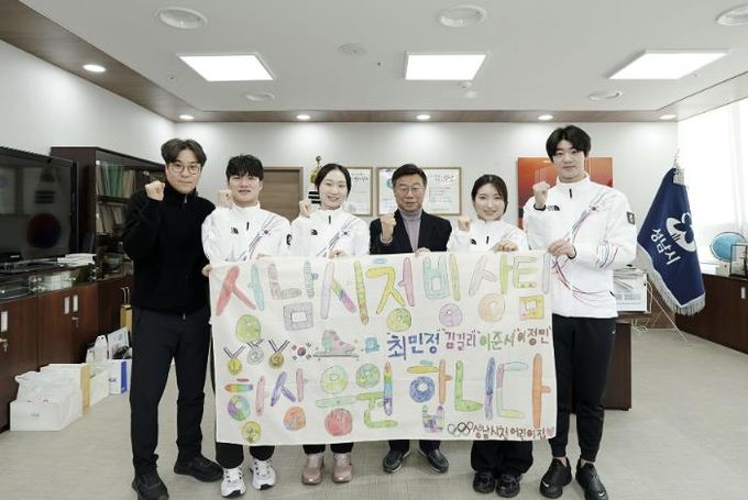 밀라노 동계올림픽 출전을 앞두고 성남시청 소속 빙상팀 선수단이 지난 1월 21일 시장 집무실에서 성남시청 어린이집 아동들의 응원 메시지가 담긴 현수막을 들고 기념사진을 찍고 있다